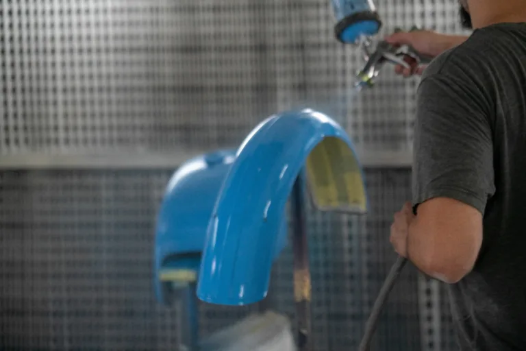 Specialist using spray gun for painting car details